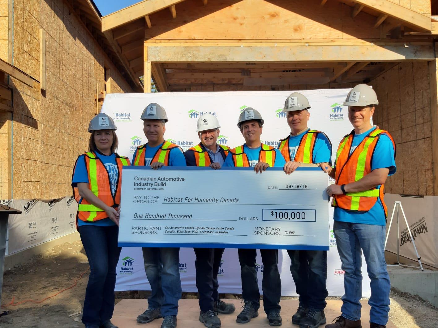 Habitat Canada President and CEO, Mark Rodgers, holds cheque from Canadian Automotive Industry Build partners