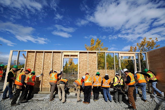 Global Village volunteers raising a wall for a future Habitat home