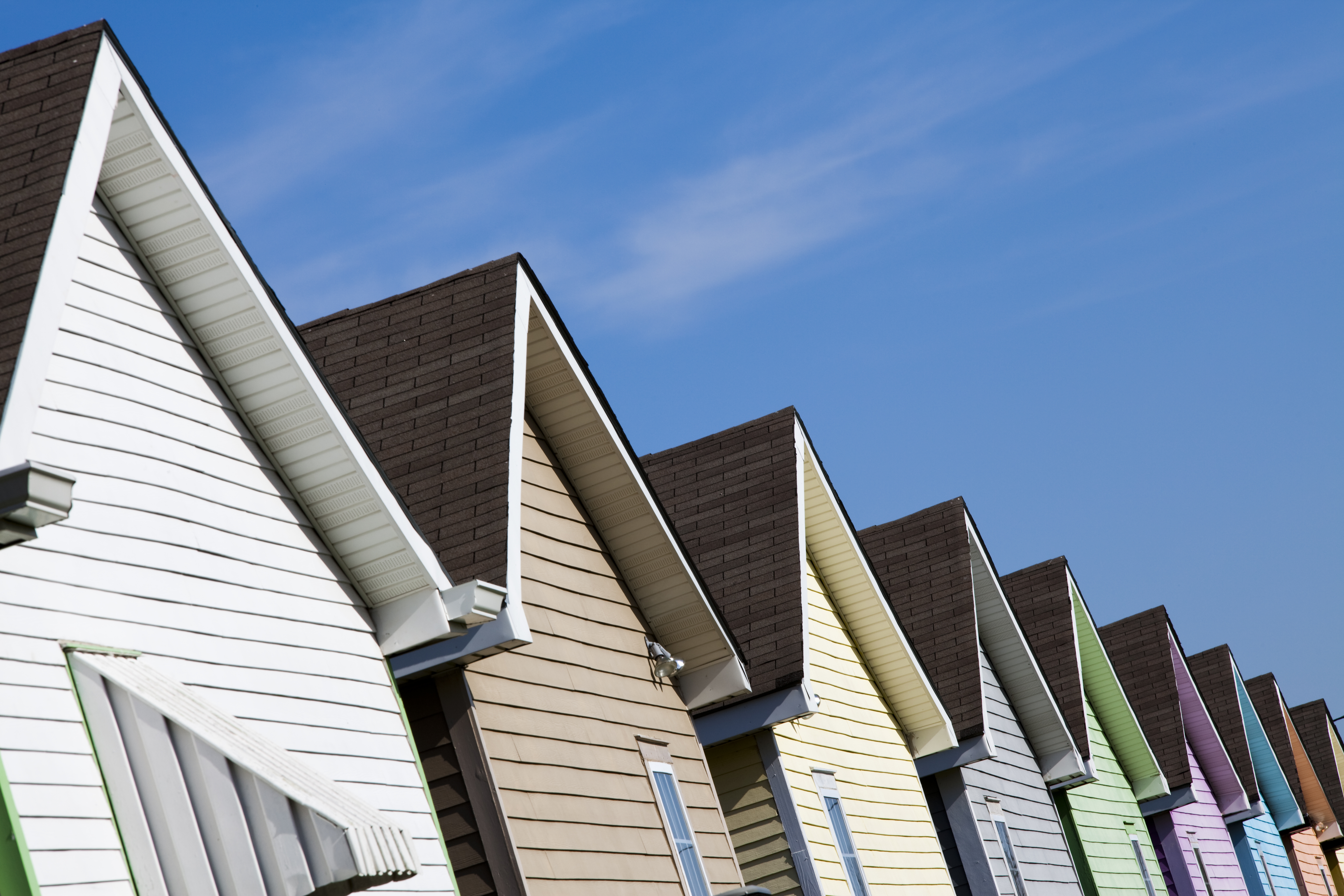 Roofs of multiple houses side by side and the blue sky