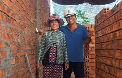 Habitat Vietnam homeowners Trang and Van stand in their partially constructed Habitat home.