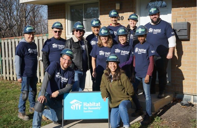Workers standing outside of a completed Habitat home